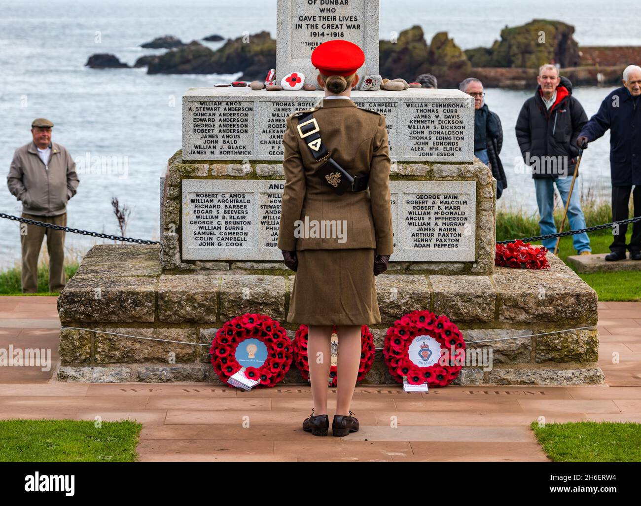 Femme soldat posant une couronne de pavot au mémorial de guerre lors de la cérémonie du jour du souvenir, Dunbar, East Lothian, Écosse, Royaume-Uni Banque D'Images
