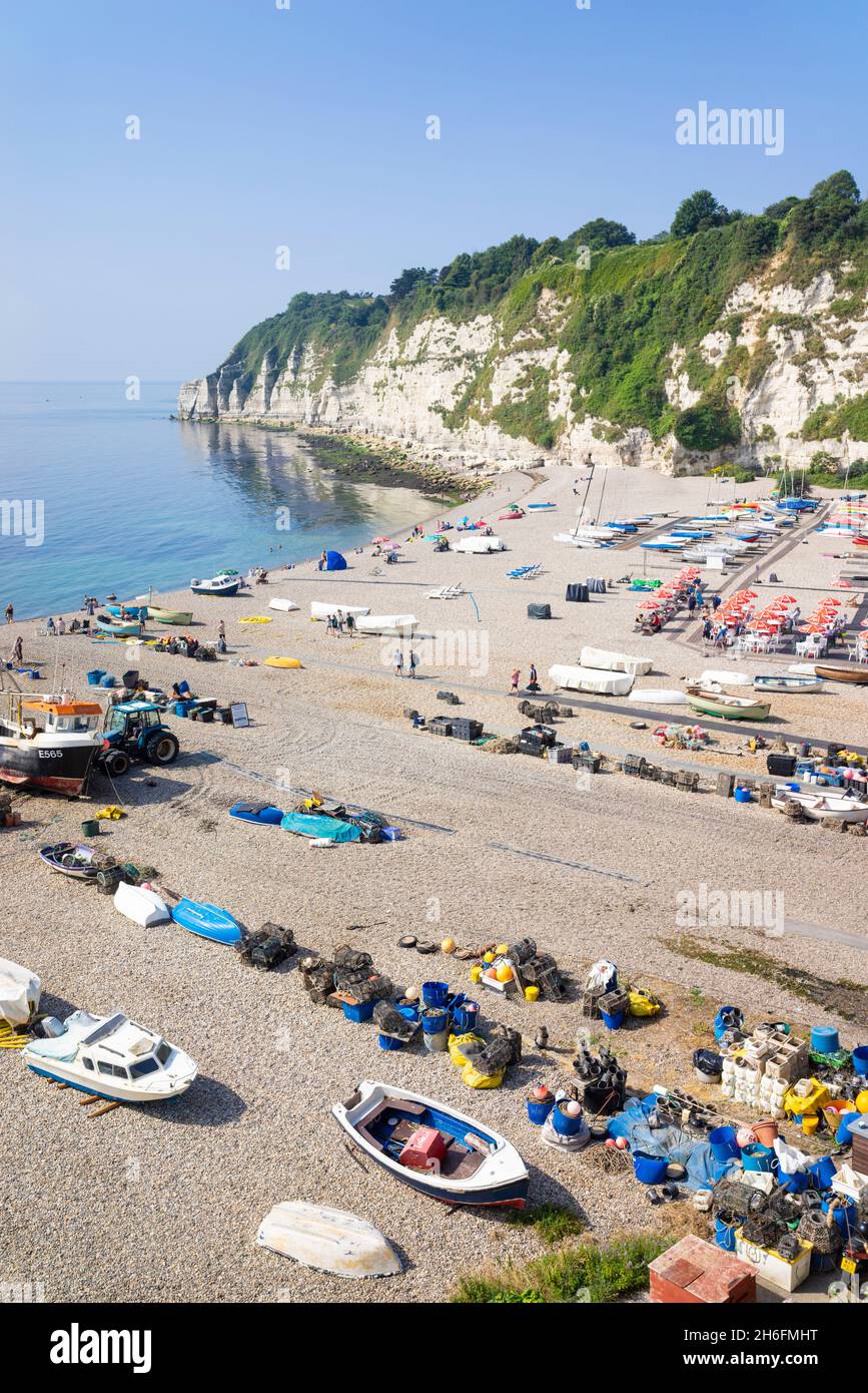 Beer Devon beaucoup de gens se sont assis sur la plage de galets parmi les bateaux de pêche sur la plage de Beer Devon Angleterre GB Europe Banque D'Images