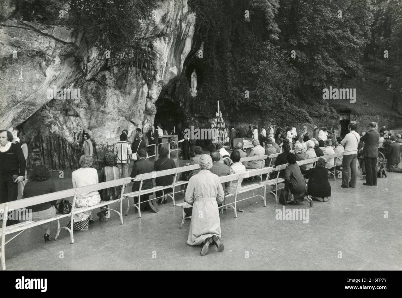 Fidèles catholiques priant devant notre-Dame de Lourdes au sanctuaire de Massabielle, France 1979 Banque D'Images