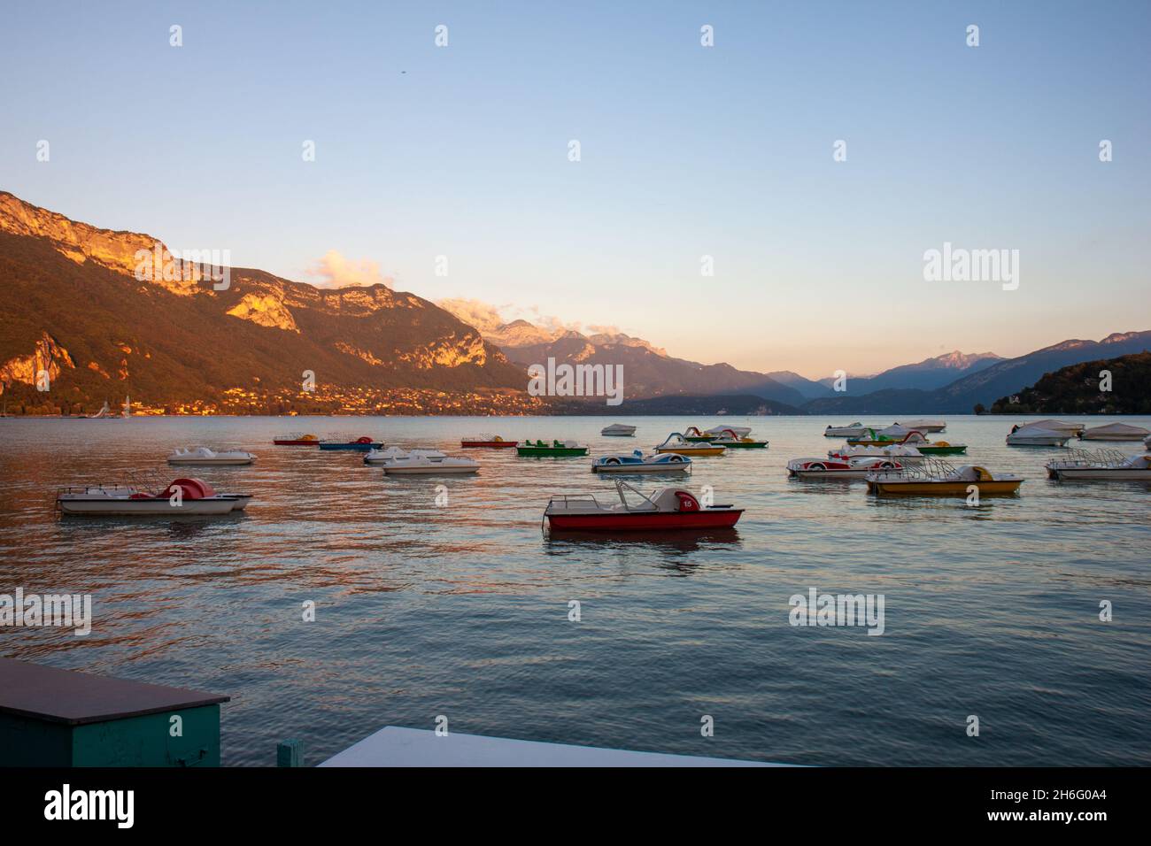 Coucher de soleil sur le lac avec des bateaux et des montagnes, Annecy, France Banque D'Images