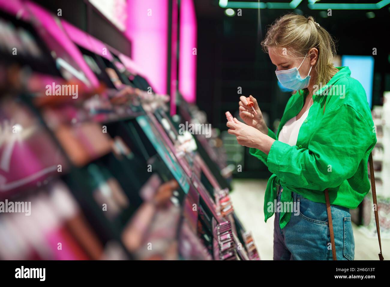 Femme essayant des produits cosmétiques dans le magasin de cosmétiques. Banque D'Images