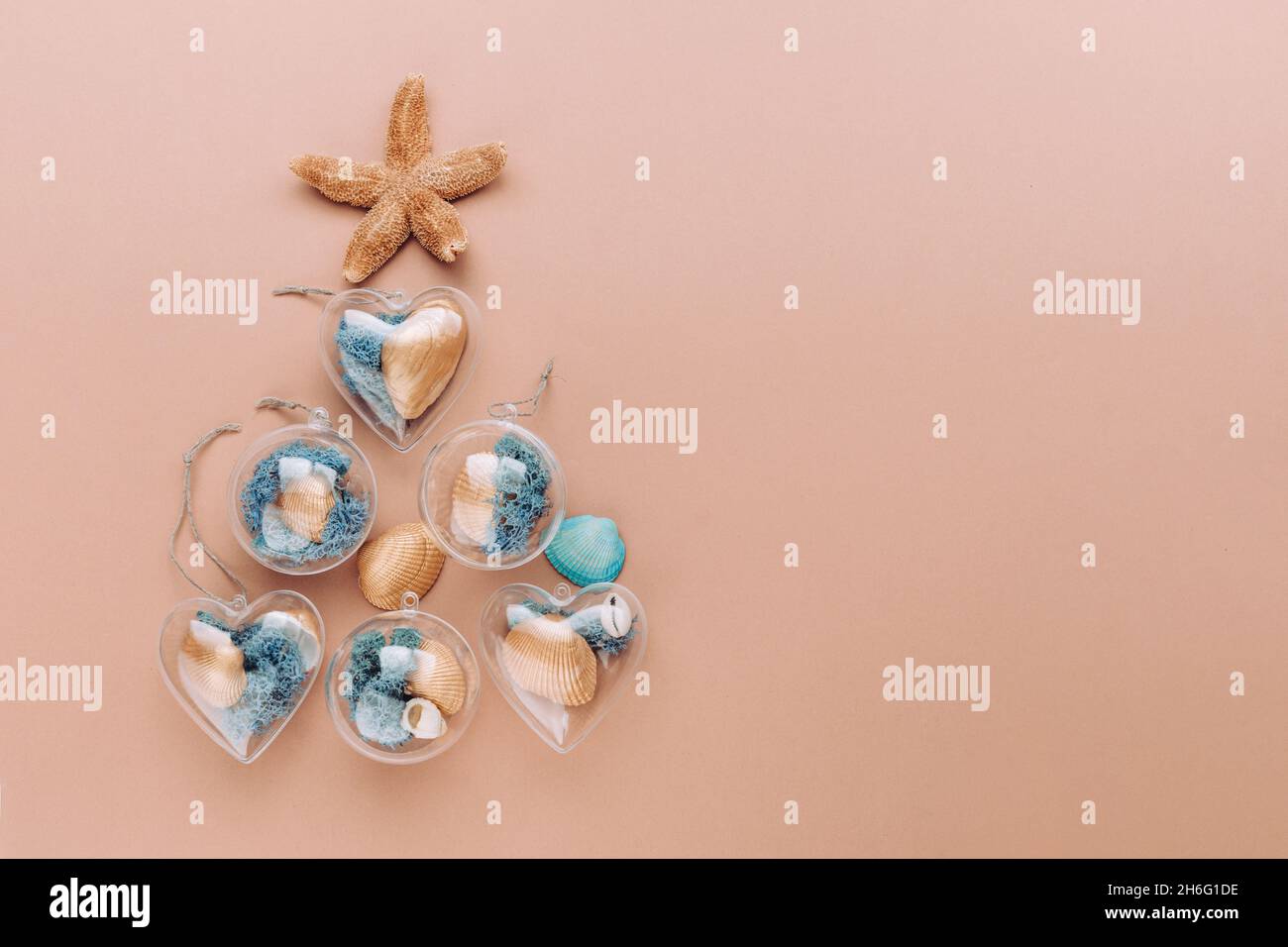 Arbre de Noël créatif fait à partir de décorations de bricolage avec étoiles de mer, or et bleu peint seashell et de mousse sur fond beige avec espace vide pour le texte. Banque D'Images