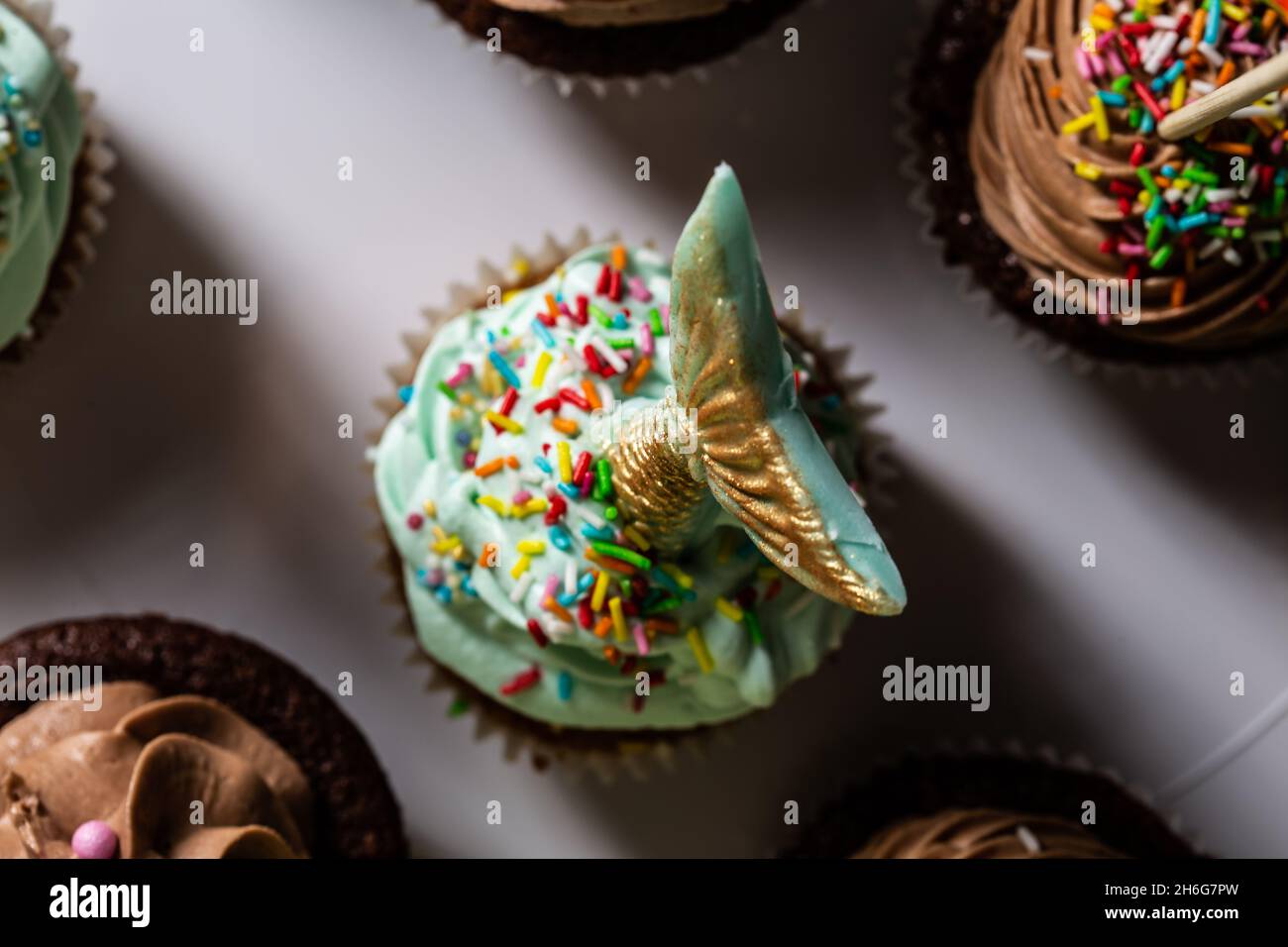 Queue de sirène verte faite à la main sur du chocolat sur un muffin au sucre au chocolat pâtisserie à la main pour une fête d'anniversaire Banque D'Images