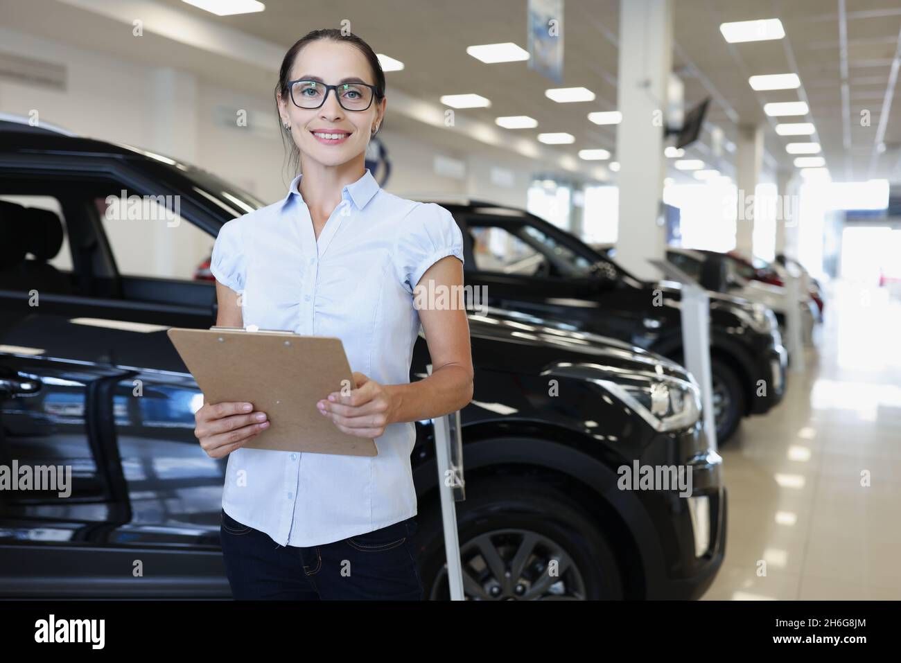 Portrait d'une femme souriante en lunettes du directeur des ventes de voitures Banque D'Images