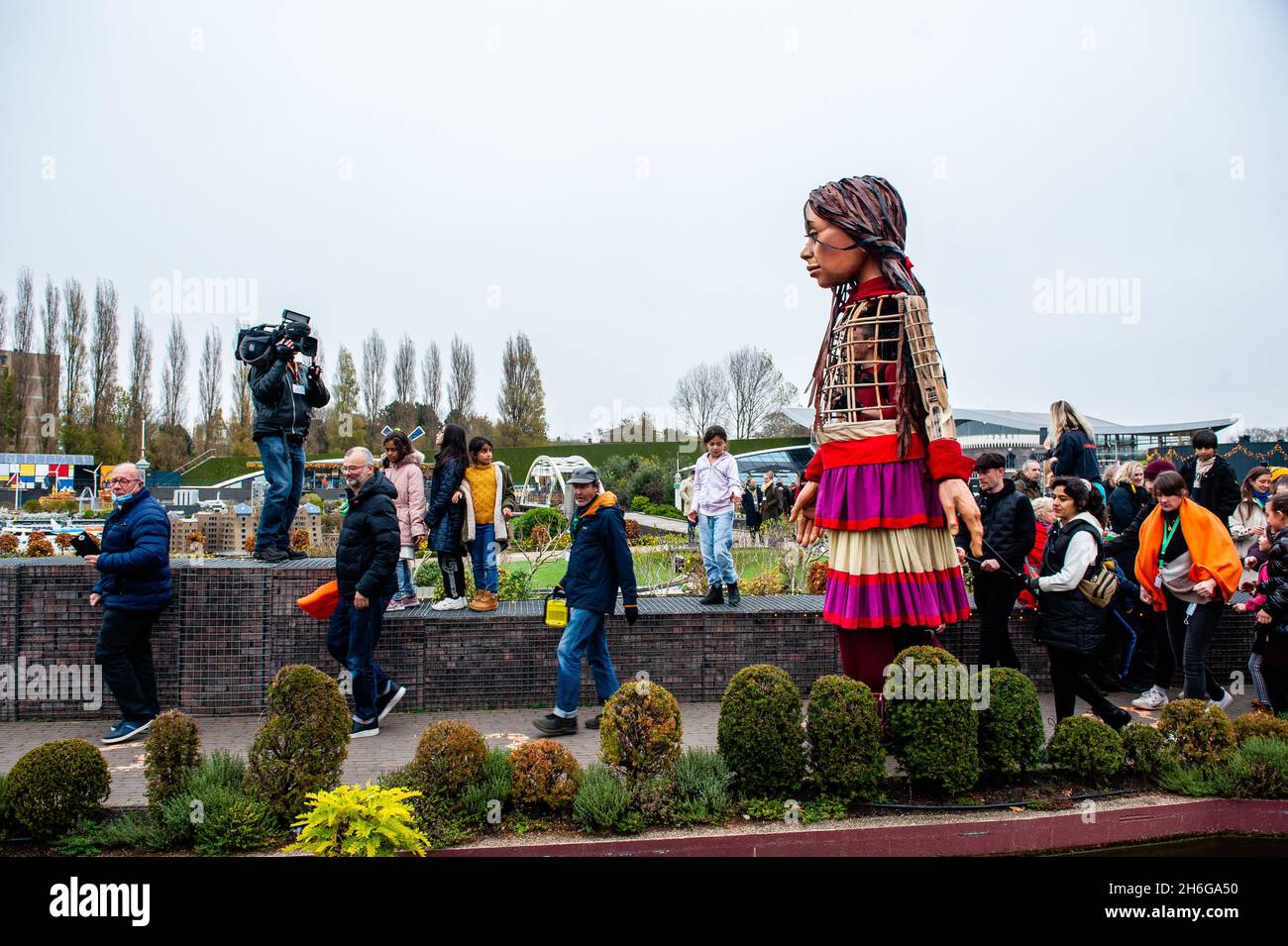 Les enfants suivent Little Amal au cours du festival.Amara, un nouveau centre culturel au centre de la Haye, a organisé dans le cadre de son « Open Festival » la visite de la marionnette géante « Little Amal », une jeune fille syrienne réfugiée de neuf ans et plus de 11 mètres de hauteur jusqu'au parc miniature, Madurodam.Elle est invitée à participer au Festival en tant qu'invitée spéciale dans la ville pour attirer l'attention à travers l'Europe sur le sort des jeunes réfugiés qui ont fui la Syrie.Amal a été reçu à l'extérieur du parc par un groupe d'enfants, après qu'elle a pu se promener autour de l'échelle 1:25 répliques du célèbre néerlandais Banque D'Images