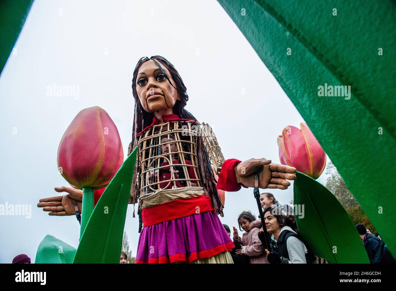 Little Amal est entouré d'un tas de tulipes géantes.Amara, un nouveau centre culturel au centre de la Haye, a organisé dans le cadre de son 'Open Festival', la visite de la marionnette géante 'Little Amal', une jeune fille de réfugiés syriens de neuf ans et de plus de 11 mètres de haut au parc miniature, Madurodam.Elle est invitée à participer au Festival en tant qu'invitée spéciale dans la ville pour attirer l'attention à travers l'Europe sur le sort des jeunes réfugiés qui ont fui la Syrie.Amal a été reçu à l'extérieur du parc par un groupe d'enfants, après qu'elle a pu se promener autour des répliques de modèle à l'échelle 1:25 de la célèbre terre hollandaise Banque D'Images