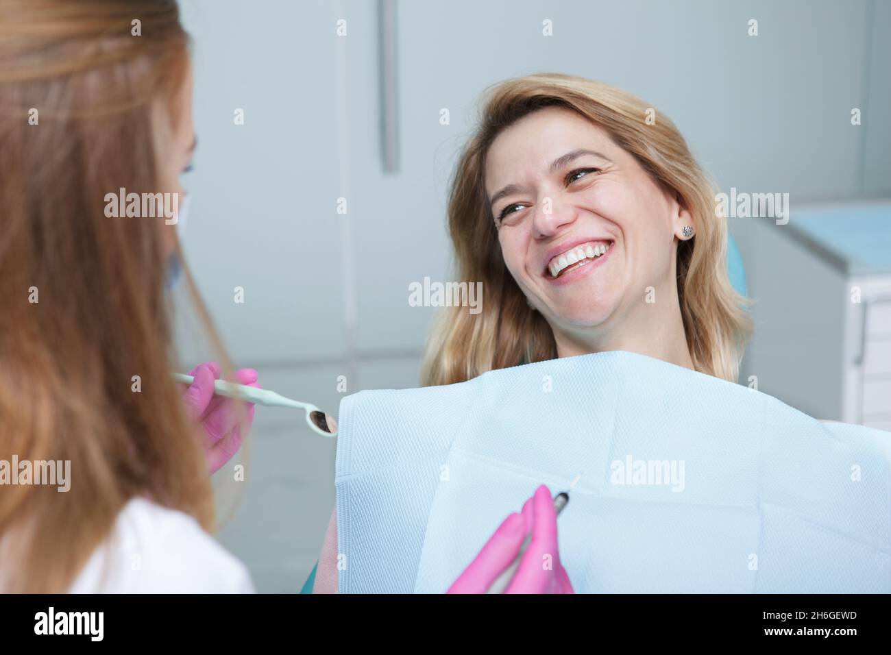 Bonne femme mûre riant, parlant à son dentiste pendant un rendez-vous dentaire Banque D'Images