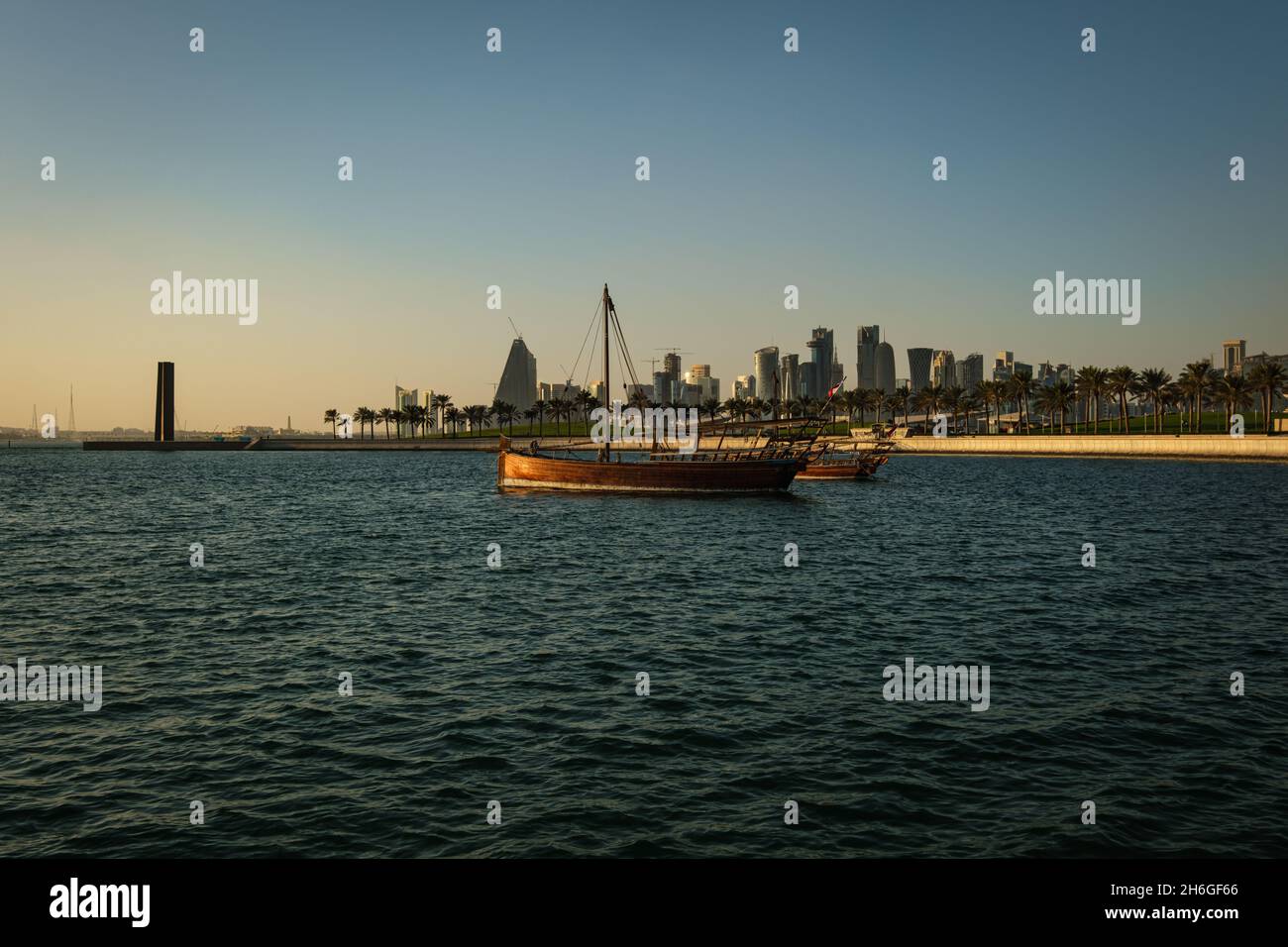 Vue de l'horizon de Doha l'après-midi montrant des huws avec des drapeaux du Qatar dans le golfe arabe en premier plan et vue de l'horizon de Doha en arrière-plan Banque D'Images