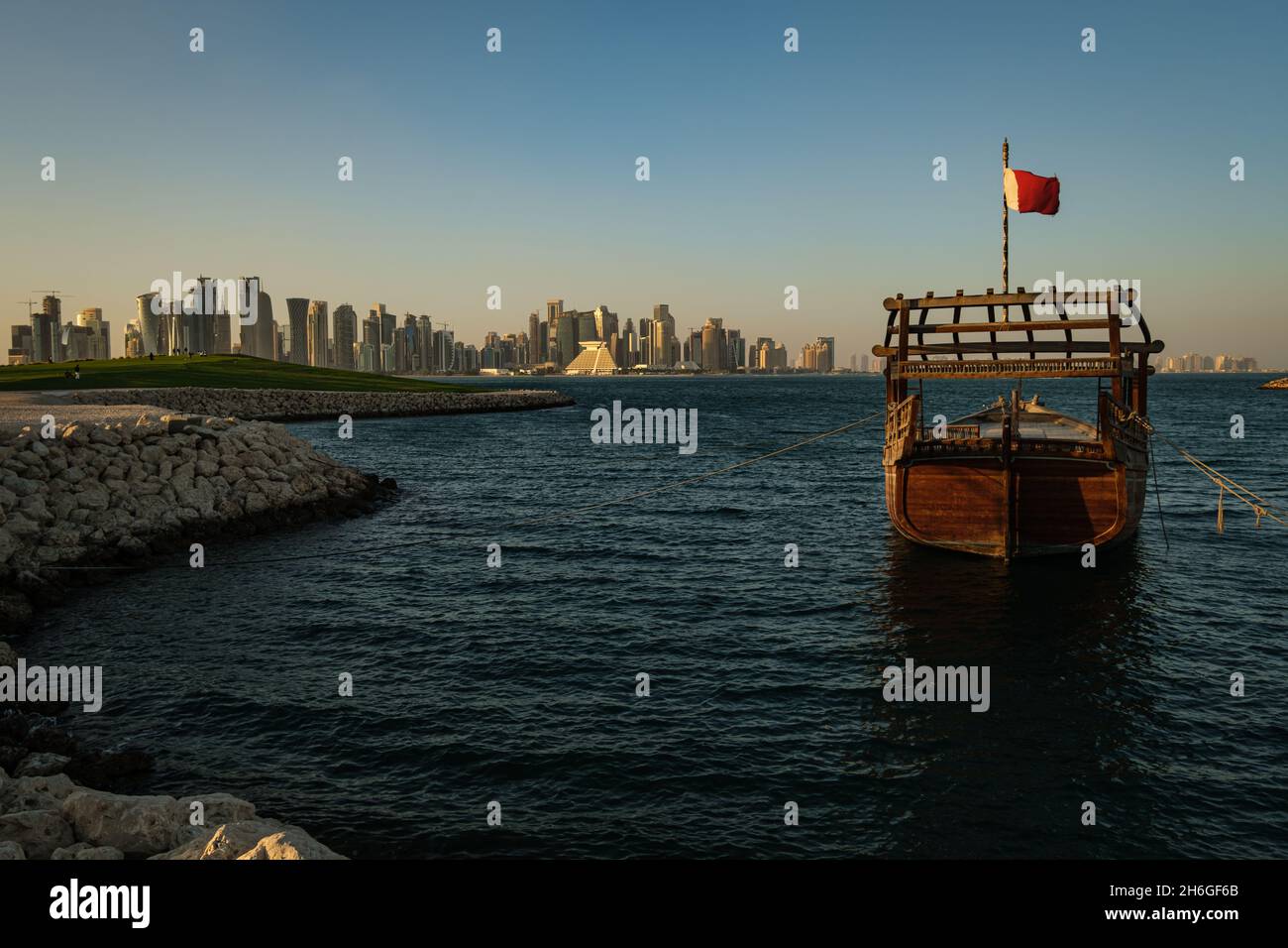 Vue de l'horizon de Doha l'après-midi montrant des huws avec des drapeaux du Qatar dans le golfe arabe en premier plan et vue de l'horizon de Doha en arrière-plan Banque D'Images
