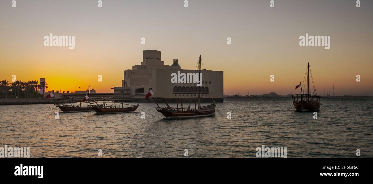 Musée d'art islamique à Doha, Qatar vue extérieure du coucher du soleil montrant l'architecture unique du musée avec des huws dans le golfe arabe en premier plan Banque D'Images