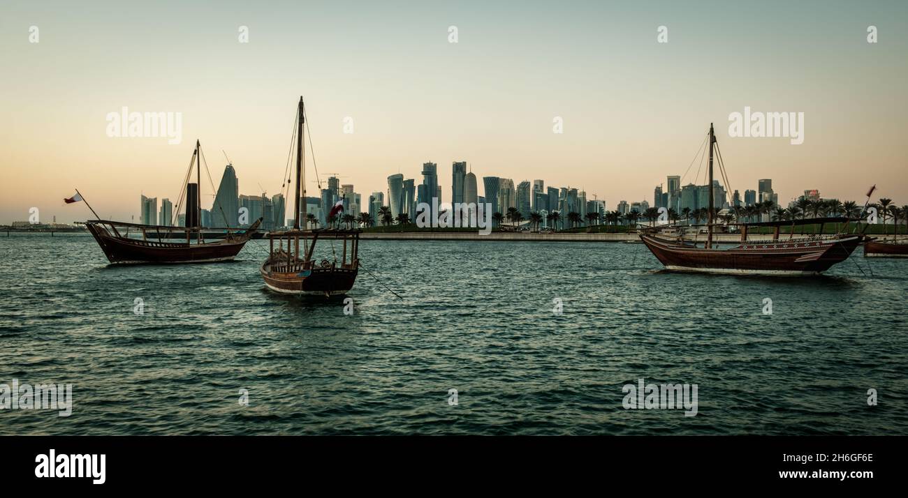 Vue de l'horizon de Doha l'après-midi montrant des huws avec des drapeaux du Qatar dans le golfe arabe en premier plan et vue de l'horizon de Doha en arrière-plan Banque D'Images