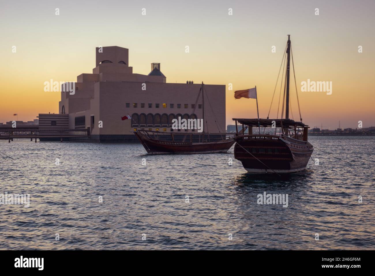 Musée d'art islamique à Doha, Qatar vue extérieure du coucher du soleil montrant l'architecture unique du musée avec des huws dans le golfe arabe en premier plan Banque D'Images