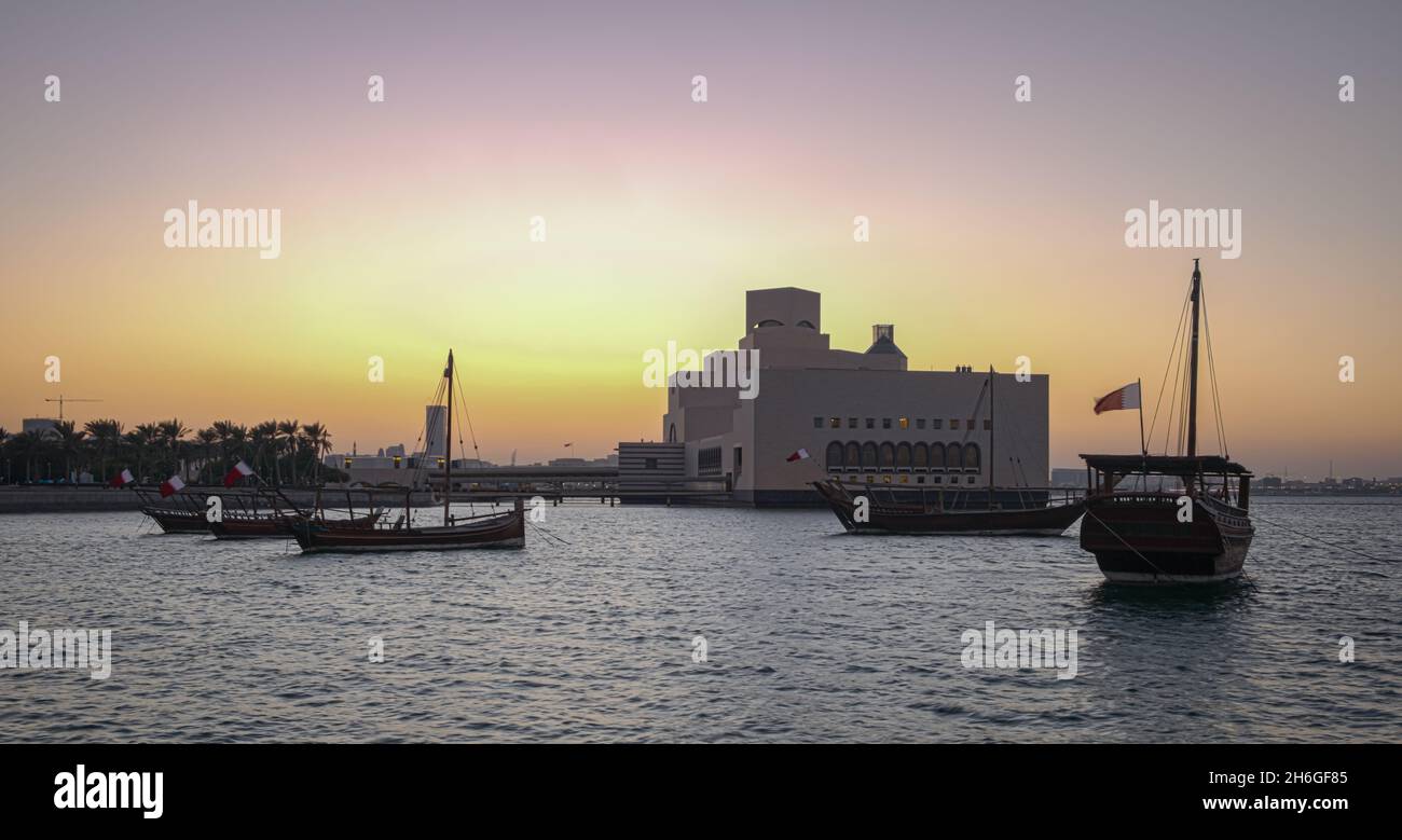 Musée d'art islamique à Doha, Qatar vue extérieure du coucher du soleil montrant l'architecture unique du musée avec des huws dans le golfe arabe en premier plan Banque D'Images