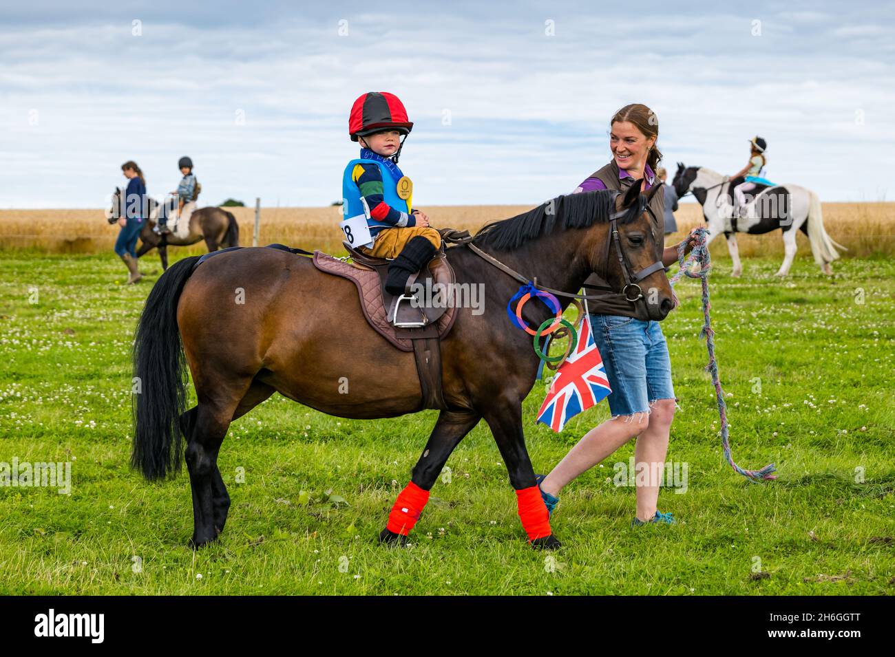 Spectacle équestre d'été : un enfant sur un poney habillé comme un jockey dans un concours de robe de fantaisie, East Lothian, Écosse, Royaume-Uni Banque D'Images