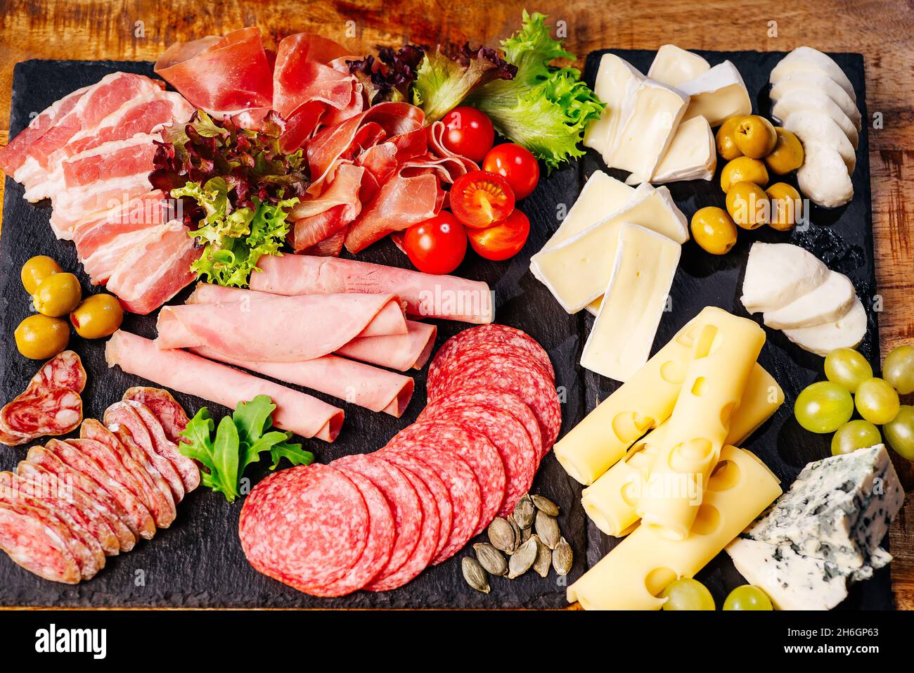 Assiette de charcuterie, antipasti avec assortiment de salami, fromage,  camembert et olives sur table en bois.divers types de viandes et saucisses  sur bois Photo Stock - Alamy
