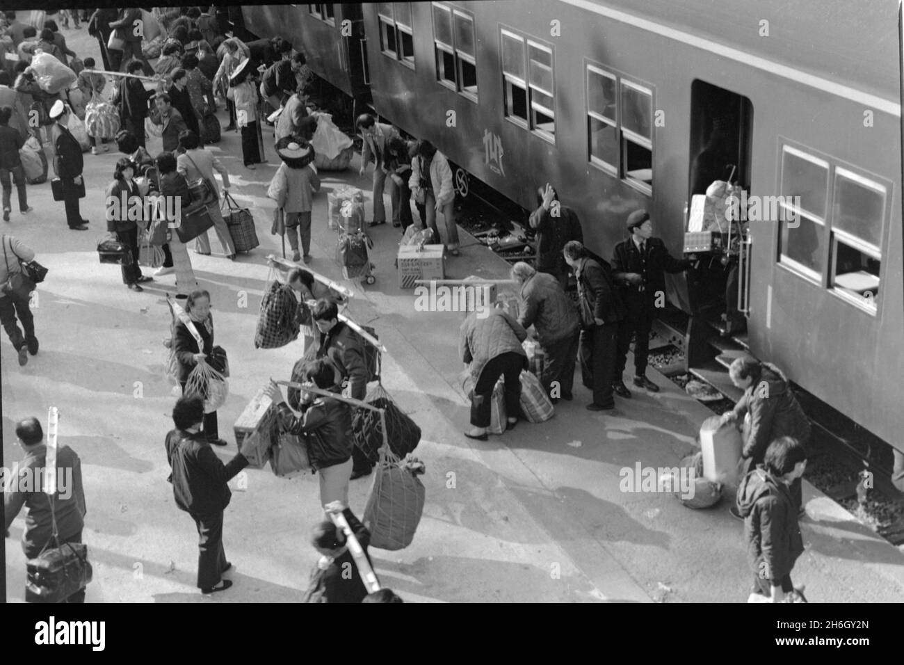 Gare de Lo Wu, Hong Kong. Vue de la station toit des passagers sortant d'un train, retour à la Chine continentale à l'année lunaire, 1981 beaucoup portent des cadeaux pour des parents, en utilisant des yokes de bambou pour équilibrer leurs colis. Les trains diesel ont été progressivement éliminés lorsque le chemin de fer Kowloon-Canton (section HK) a été électrifié au début de 1980s Banque D'Images