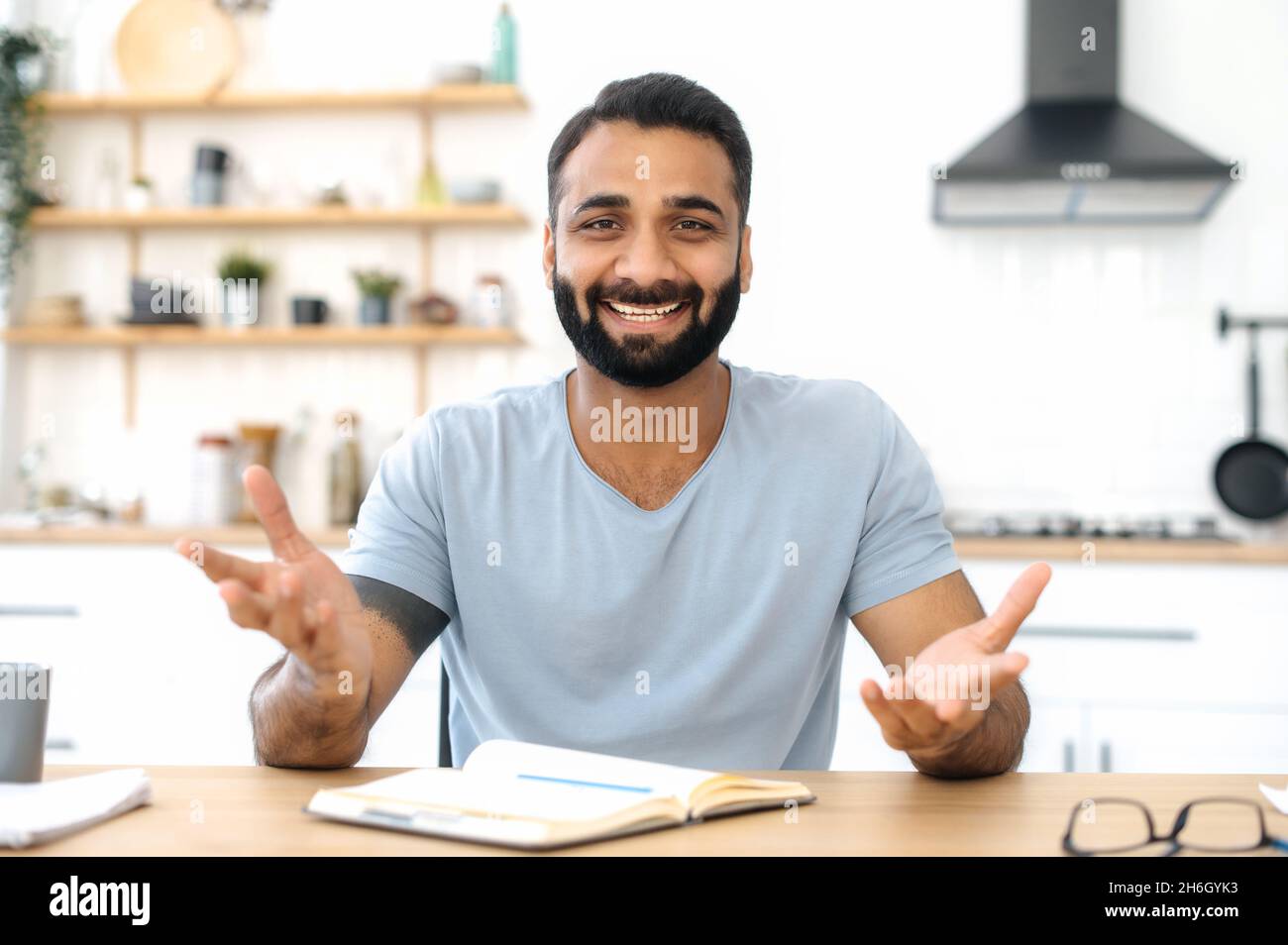 Sympathique positif personne d'affaires ou mentor indien réussi, communiquer avec un collègue ou un client lors d'une conférence téléphonique, regarde la caméra, gestuelle avec les mains, sourires agréablement, avoir un entretien en ligne Banque D'Images