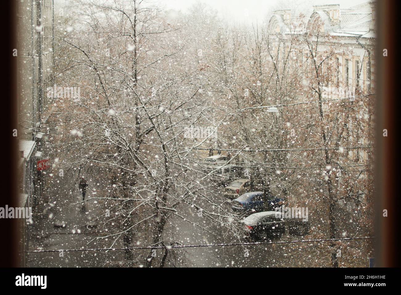 Vue sur la rue depuis la chambre par une sombre journée d'hiver.La première neige tombe dans la rue. Banque D'Images