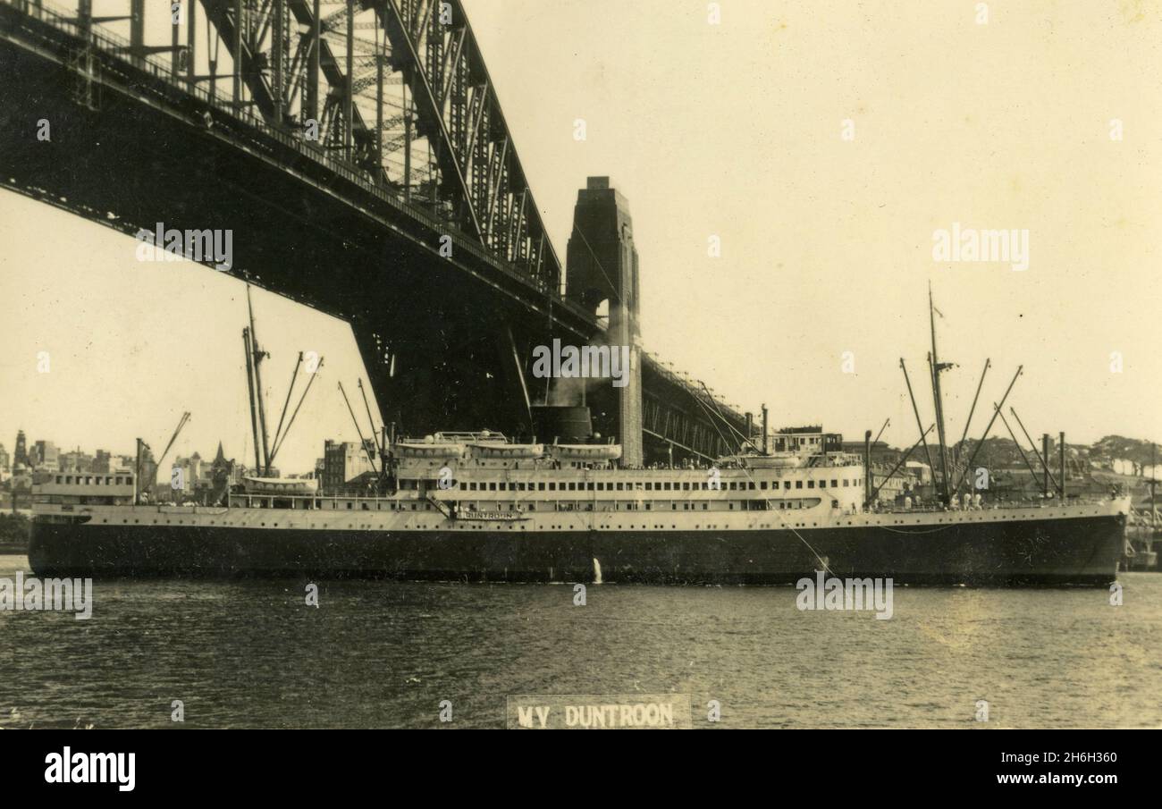 Carte postale du MV Duntroon passant sous le pont du port de Sydney, Sydney, Australie.De la collection de la famille McKechnie.MV Duntroon était un navire à moteur de passagers construit pour la Melbourne Steamship Company, qui a vu le service militaire comme un navire de croisière entre 1942 et 1949.Elle a été construite par Swan, Hunter & Wigham Richardson, Walker, Newcastle upon Tyne, et est entrée en service en 1939. Banque D'Images