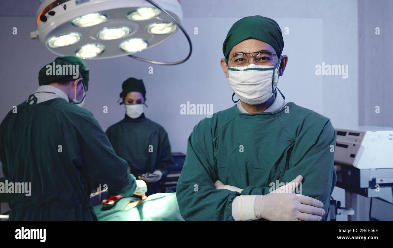 Chirurgien médecin posant avec les bras croisés, Medical Surgery médecin équipe effectuant la chirurgie patient sur la salle d'opération avec l'équipement d'électrocautérisation pour c Banque D'Images