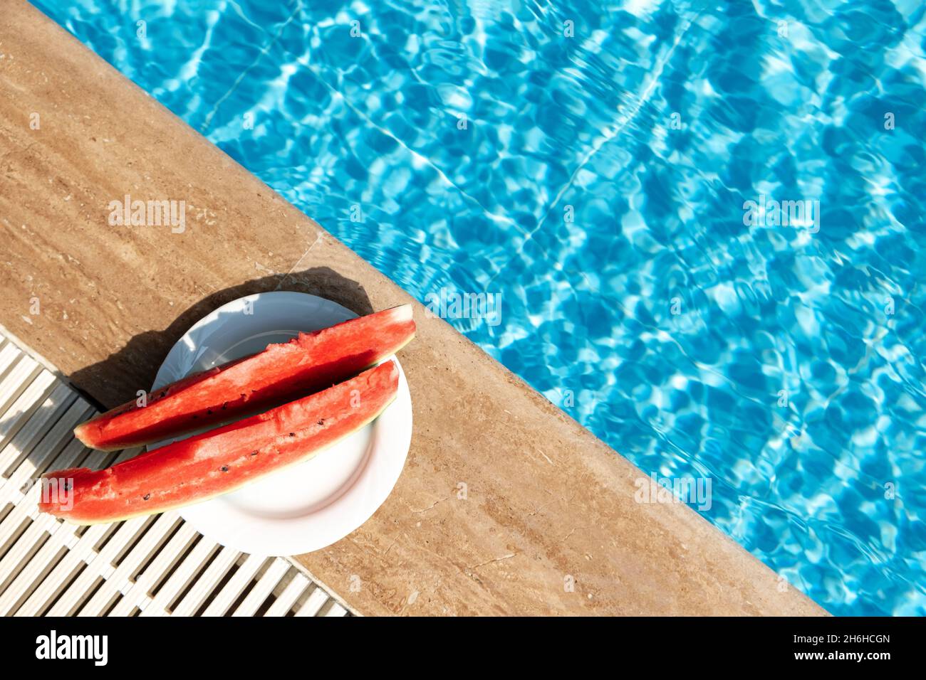 L'été avec du melon d'eau douce près de la piscine.Voyage d'été chaud, vacances et concept de vacances.Vue de dessus.Espace de copie - image Banque D'Images