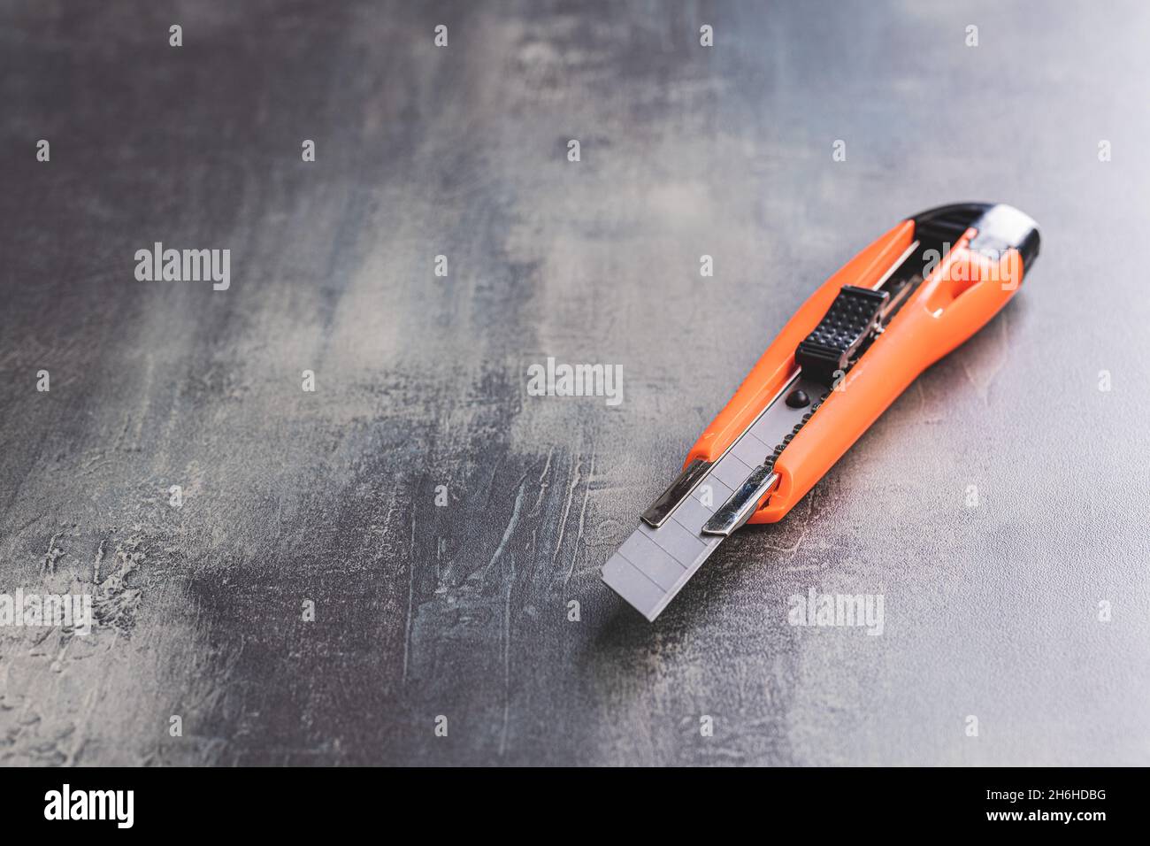 Couteau universel en plastique orange sur la table. Banque D'Images