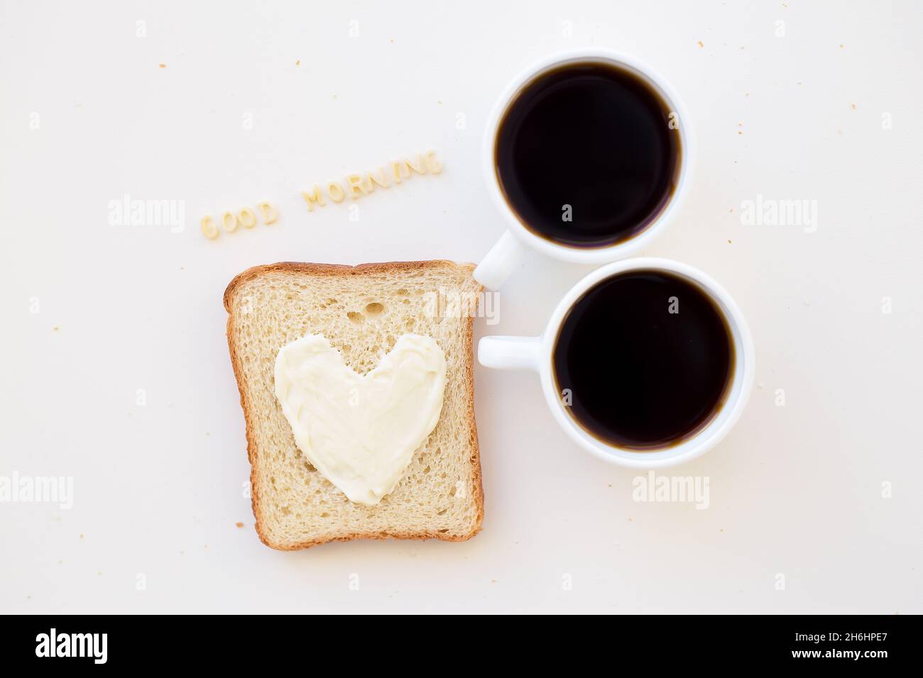 sandwich pour le petit déjeuner sous forme de coeur avec fromage - bon signe du matin et deux tasses de café Banque D'Images