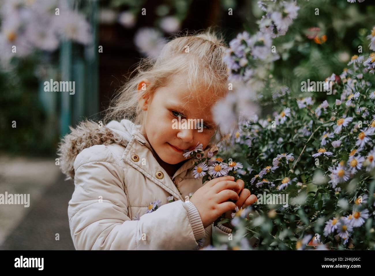 Portrait d'un enfant de 4 ans à l'extérieur.Jolie fille et fleurs.Bébé dans  une veste blanche en automne.Enfance Photo Stock - Alamy