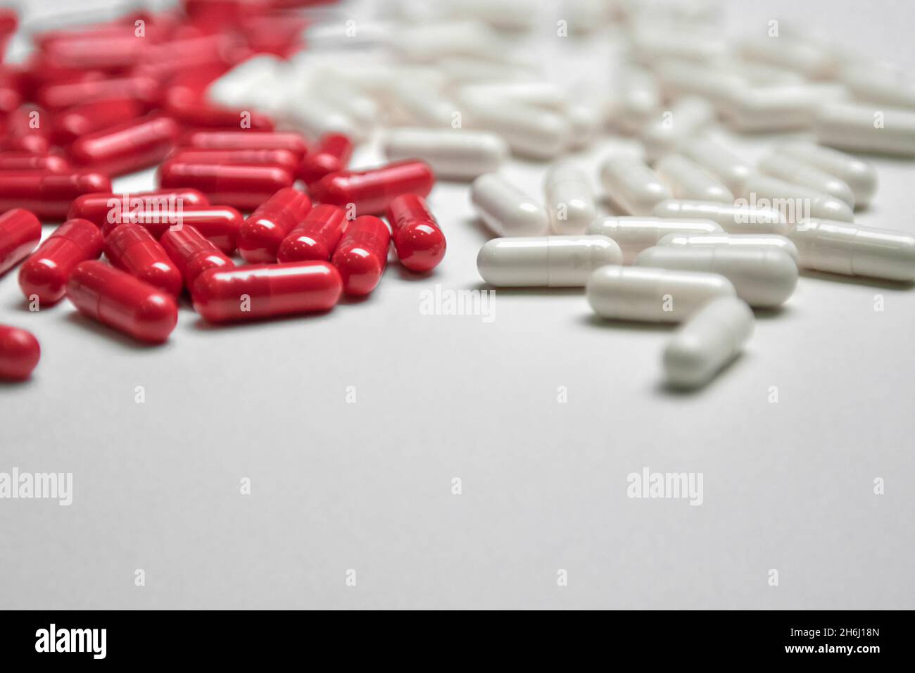 Beaucoup de pilules blanches et rouges sur un fond coloré.Suppléments et médicaments qui sont bons pour votre santé Banque D'Images