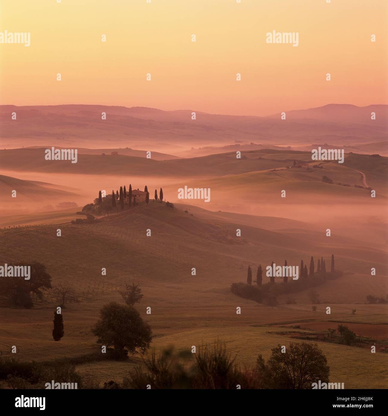 Ferme toscane avec cyprès dans un paysage brumeux au lever du soleil, San Quirico d'Orcia, province de Sienne, Toscane, Italie, Europe Banque D'Images