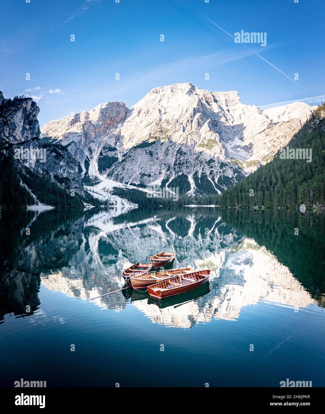 Bateaux amarrés dans le lac Braies (Pragser Wildsee) avec des montagnes reflétées dans l'eau au lever du soleil, Dolomites, Tyrol du Sud, Italie, Europe Banque D'Images