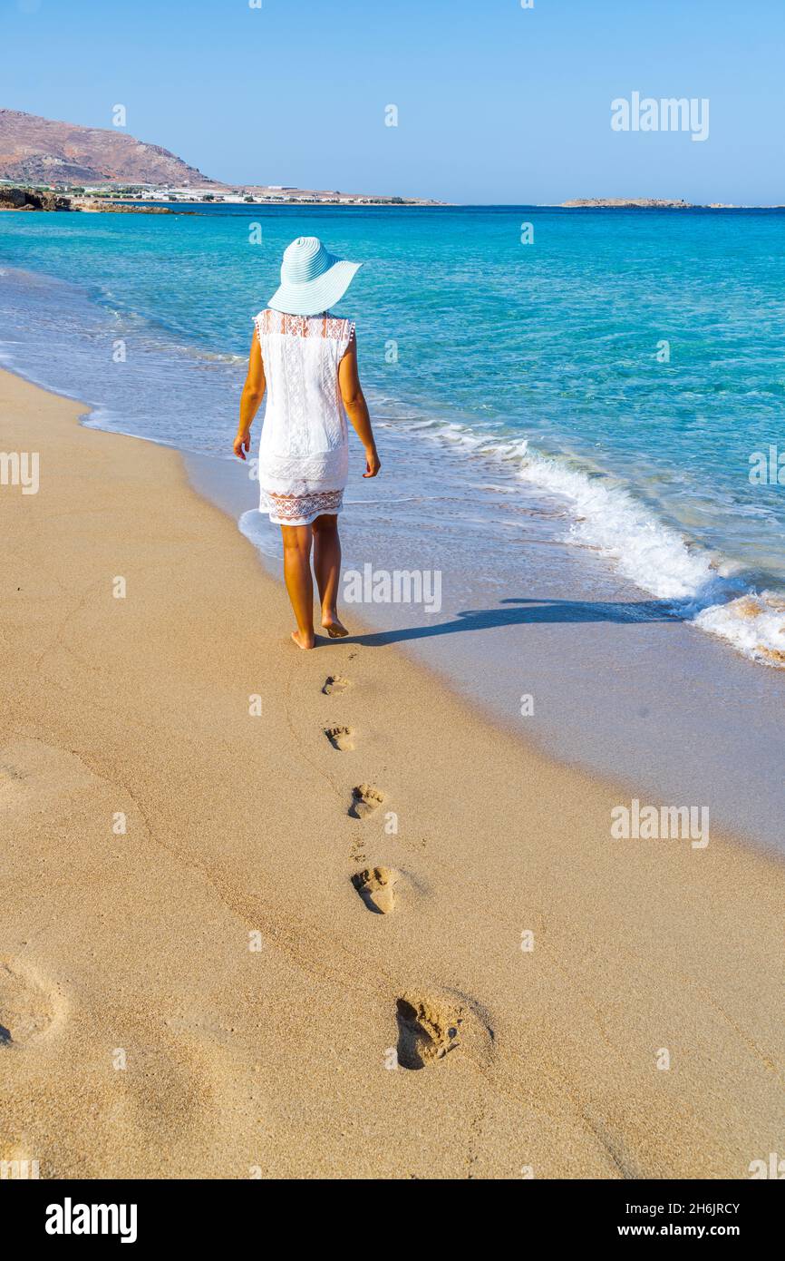 Jeune femme à la bals et au chapeau marchant sur une plage de sable, île de Crète, îles grecques, Grèce, Europe Banque D'Images