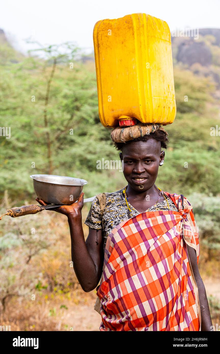 Femme avec un caniister d'eau sur sa tête, tribu Laarim, Boya Hills, Equatoria de l'est, Soudan du Sud, Afrique Banque D'Images