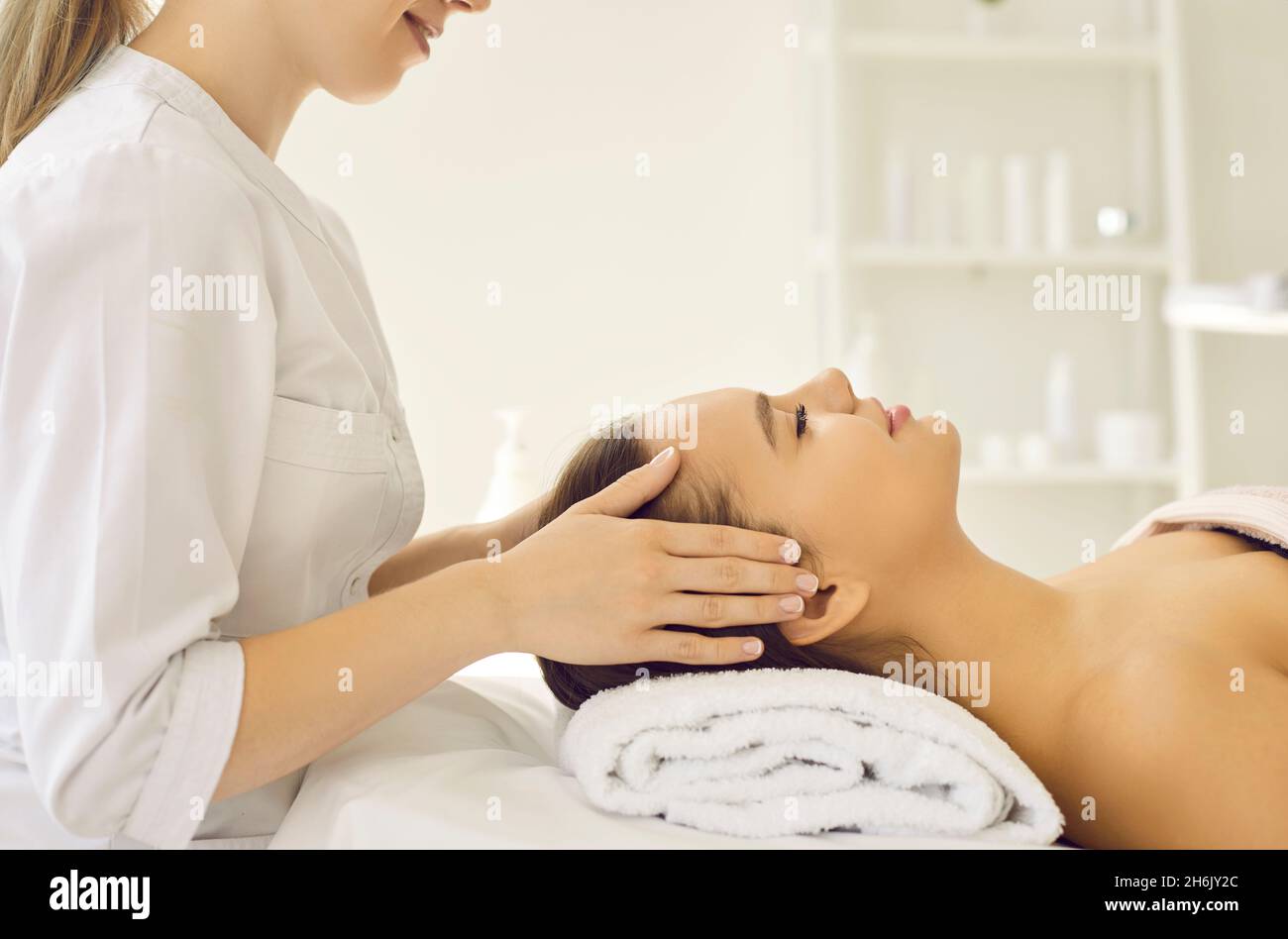 Une jeune femme heureuse et détendue se fait soigner le visage au salon de beauté et de spa Banque D'Images