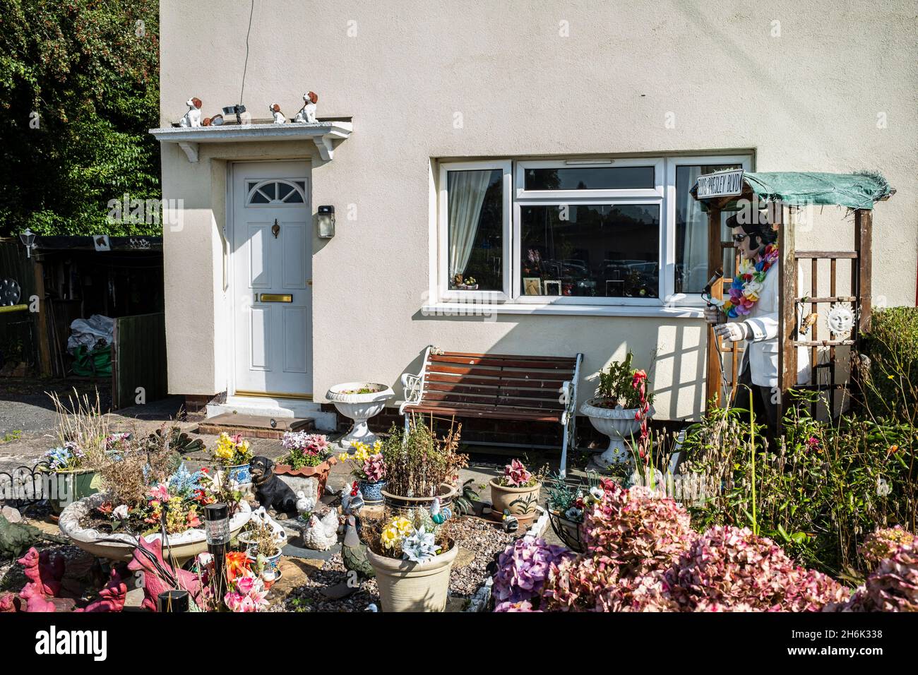 Elvis Presley modèle grandeur nature dans un jardin à l'avant avec beaucoup de pots de plantes et de décorations pour chiens, Buckley, pays de Galles, Royaume-Uni, Banque D'Images