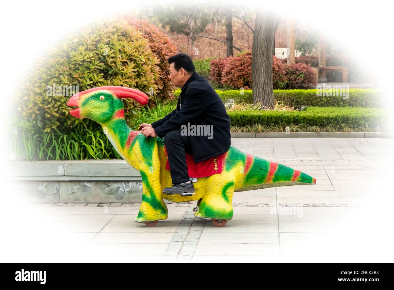 Un homme chinois mûr traverse un parc de dinosaures dans la province de Shaanxi, en Chine Banque D'Images