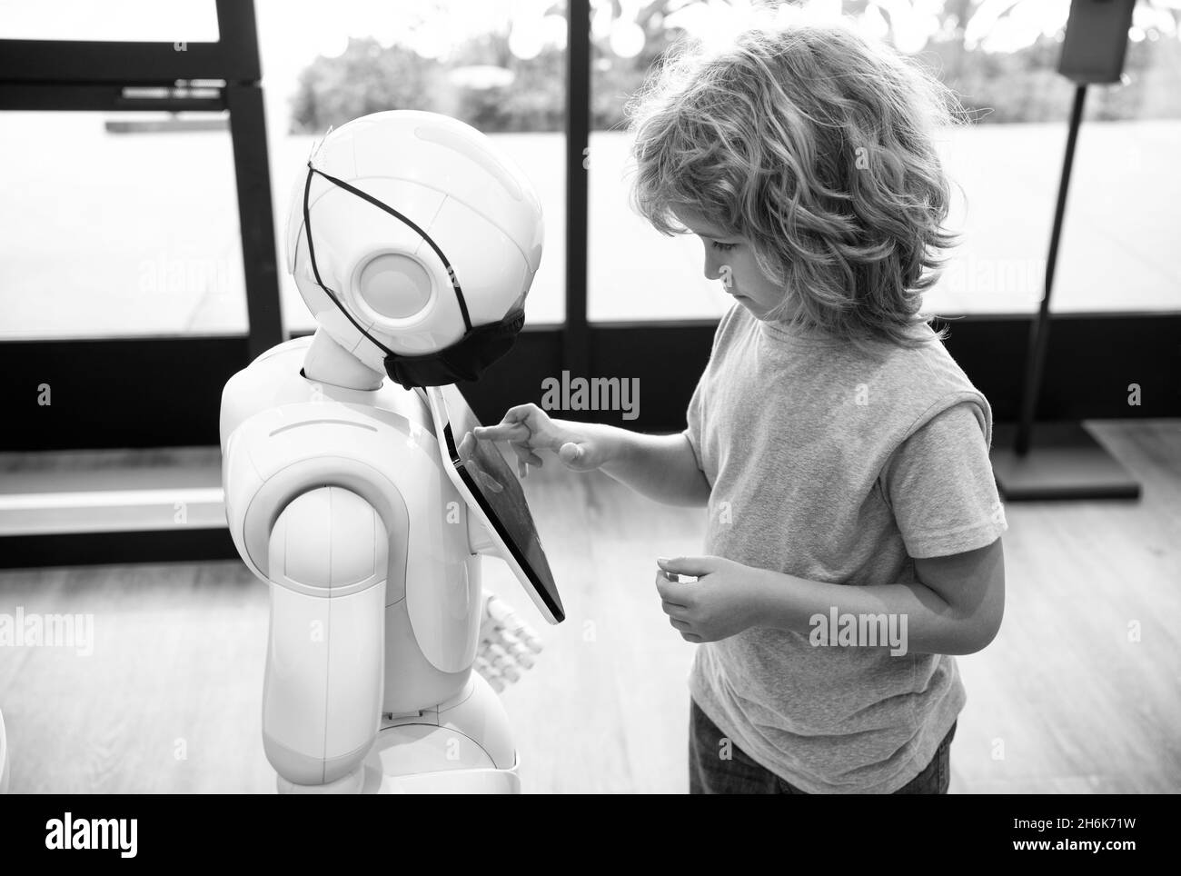 un petit garçon intelligent communique avec la technologie d'assistant robot pour l'éducation moderne, la robotique Banque D'Images