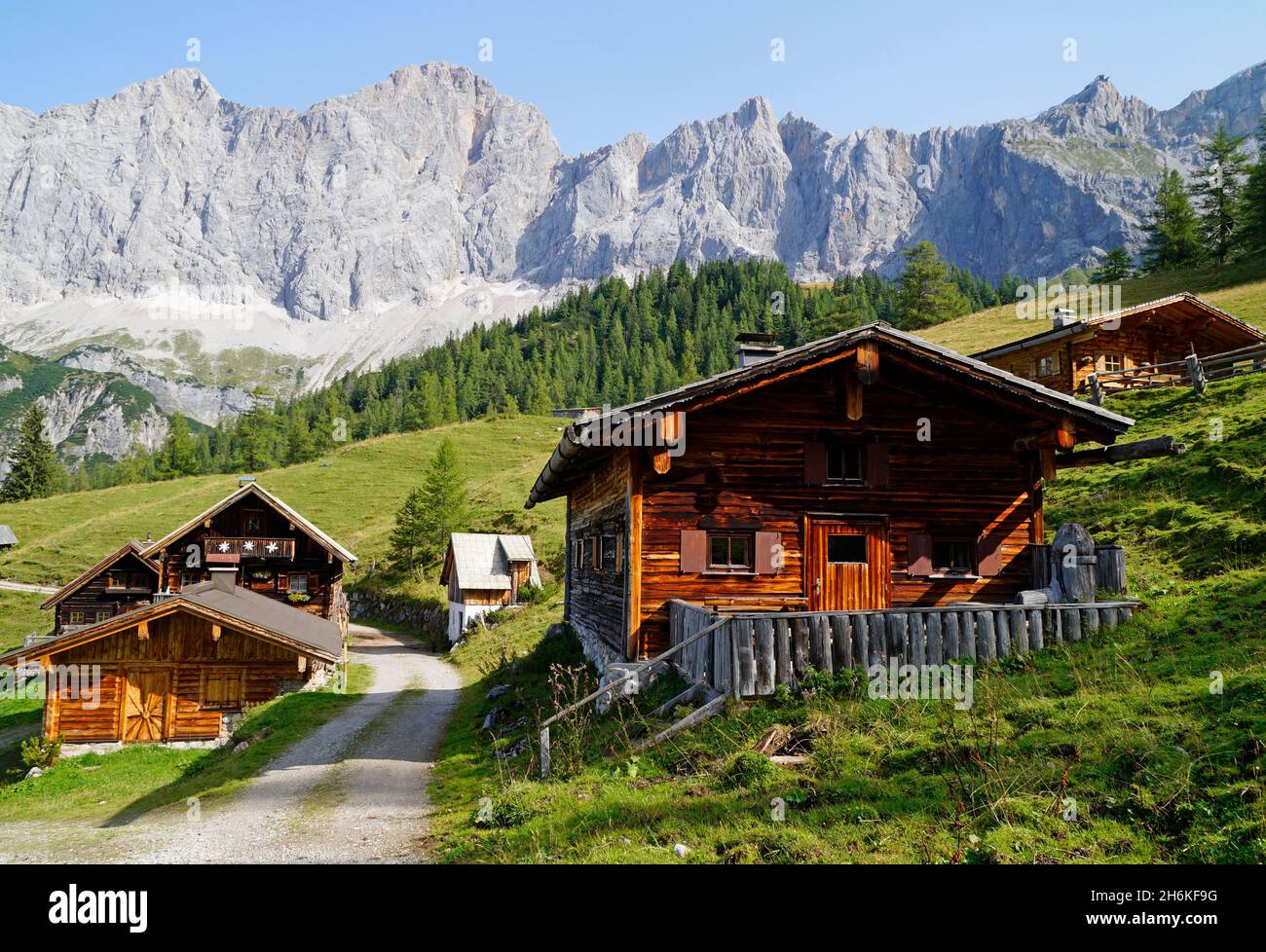 Un chemin menant à travers le paysage alpin avec des chalets en rondins dans la région de Dachstein en Autriche (Neustatt Alm en Styrie) Banque D'Images