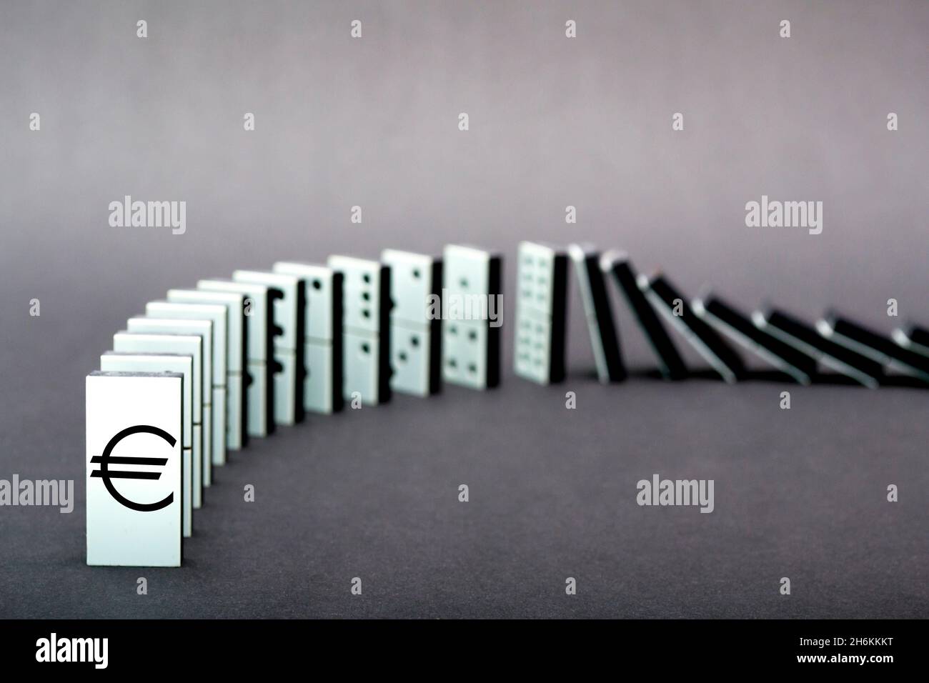 Dominos tombant en rangée, fond gris Banque D'Images