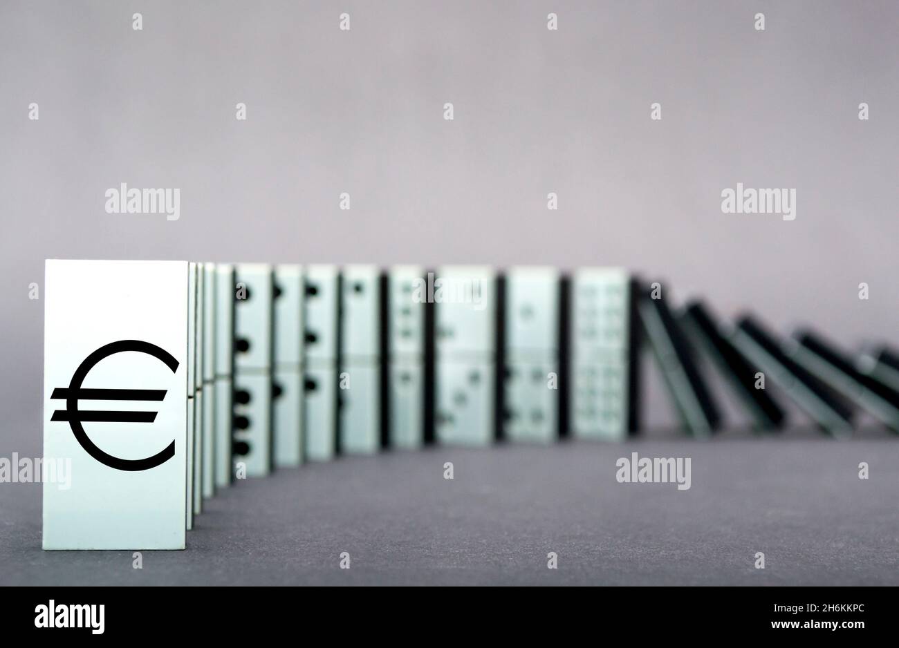 Dominos tombant en rangée, fond gris Banque D'Images