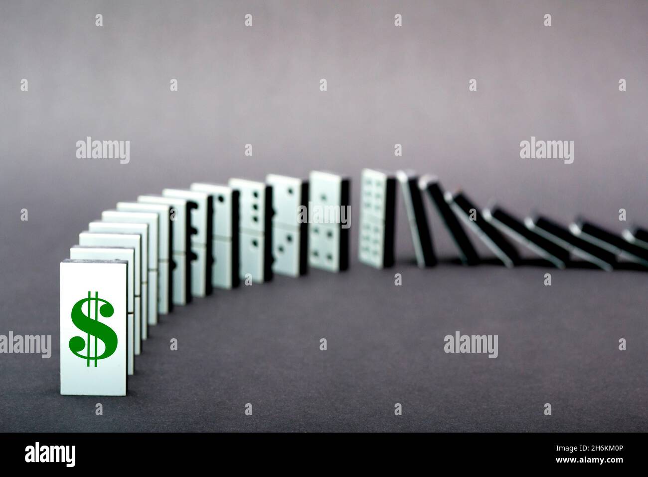 Dominos tombant en rangée, fond gris Banque D'Images