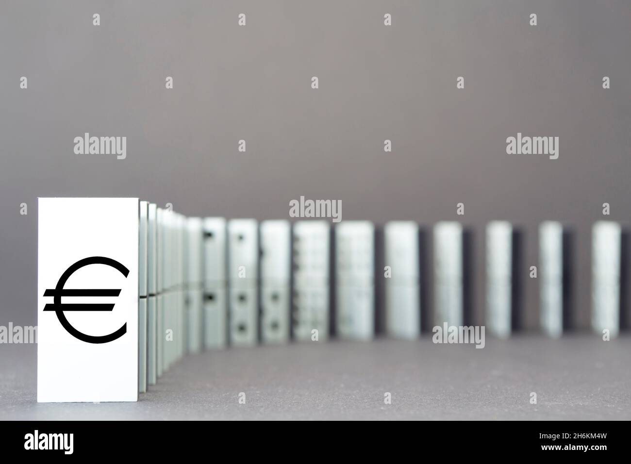 Dominos tombant en rangée, fond gris Banque D'Images