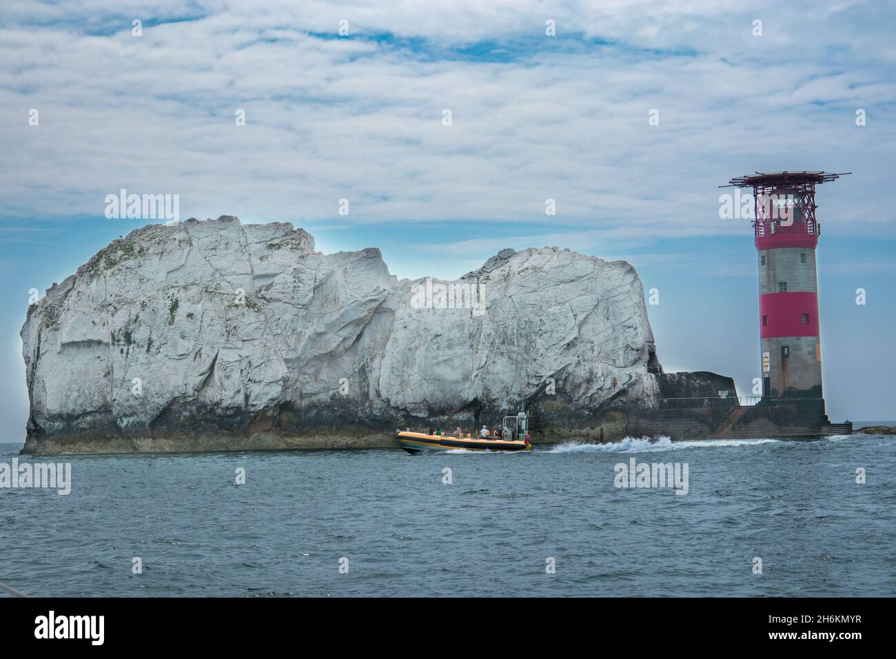 The Needles and Lighthouse on the Solent on the Isle of Wight Hampshire England avec un bateau de croisière jaune qui passe Banque D'Images