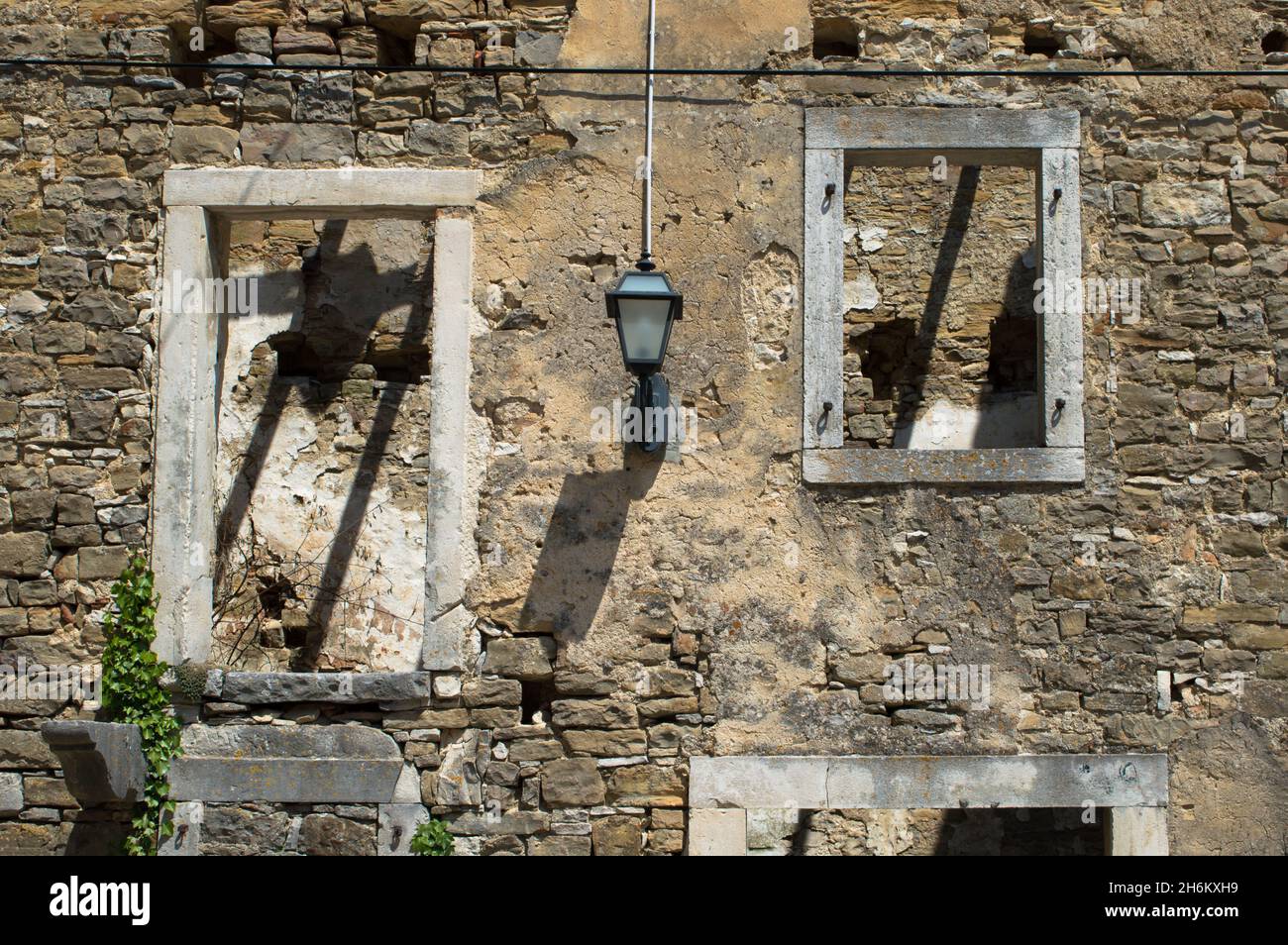 Fenêtres d'une ancienne maison en pierre abandonnée et ruinée dans un petit village Oprtalj Portole dans le centre de l'Istrie, Croatie Banque D'Images