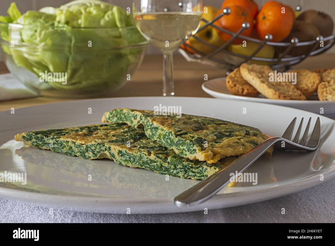 frittata con spinaci nel piatto con insalata verde 2 Banque D'Images