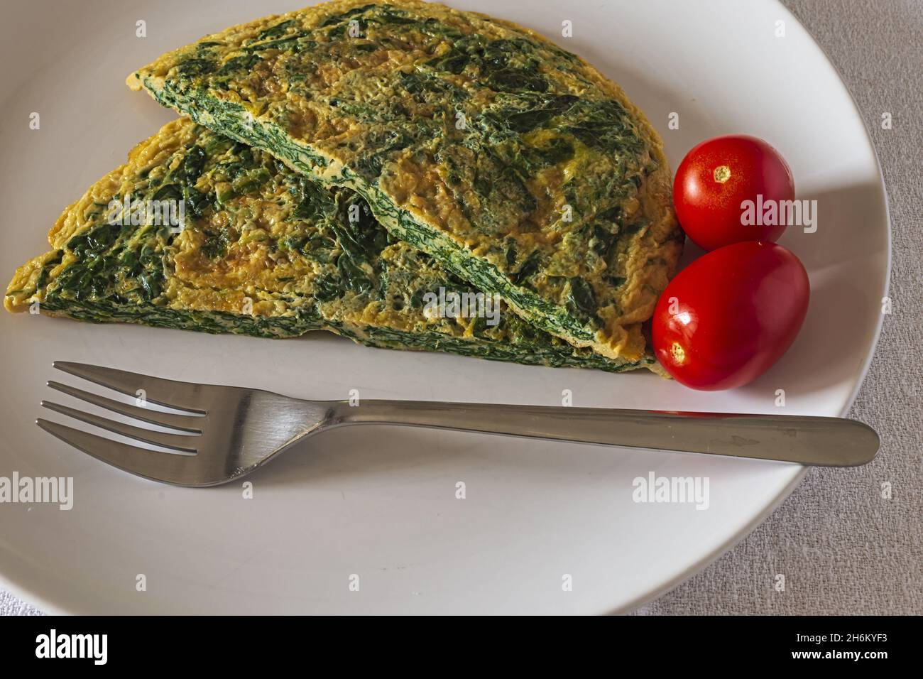 frittata con spinaci nel piatto con insalata verde 3 Banque D'Images