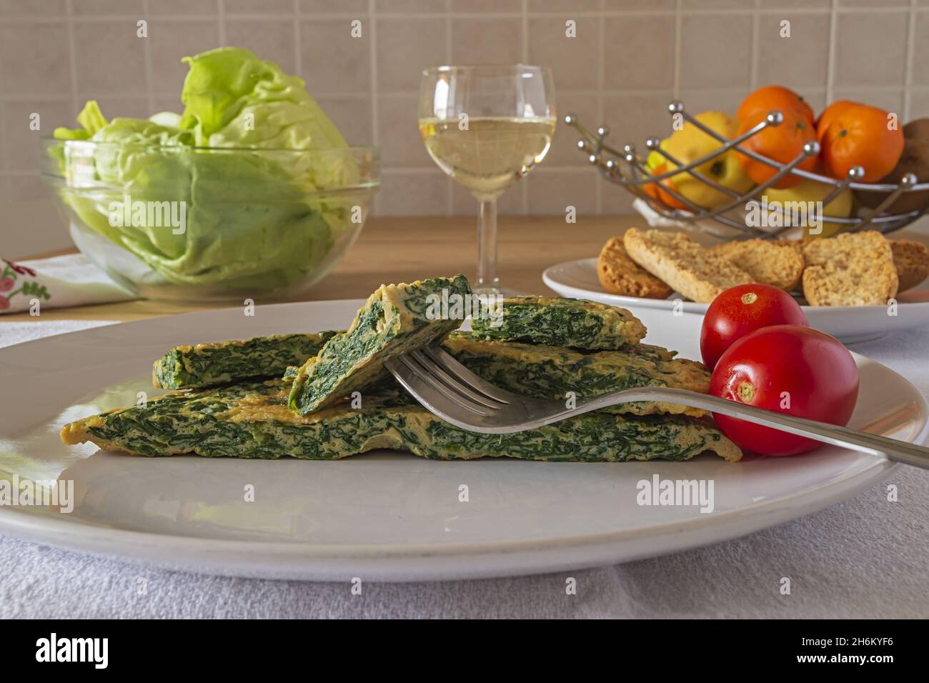 frittata con spinaci nel piatto con insalata verde 4 Banque D'Images