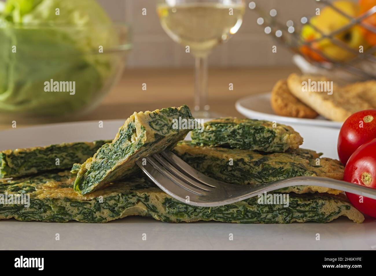 frittata con spinaci nel piatto con insalata verde 5 Banque D'Images