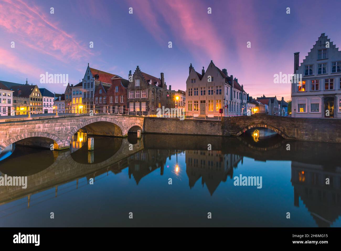 Bâtiments médiévaux historiques le long d'un canal à Bruges pendant le coucher de soleil étonnant, Belgique Banque D'Images