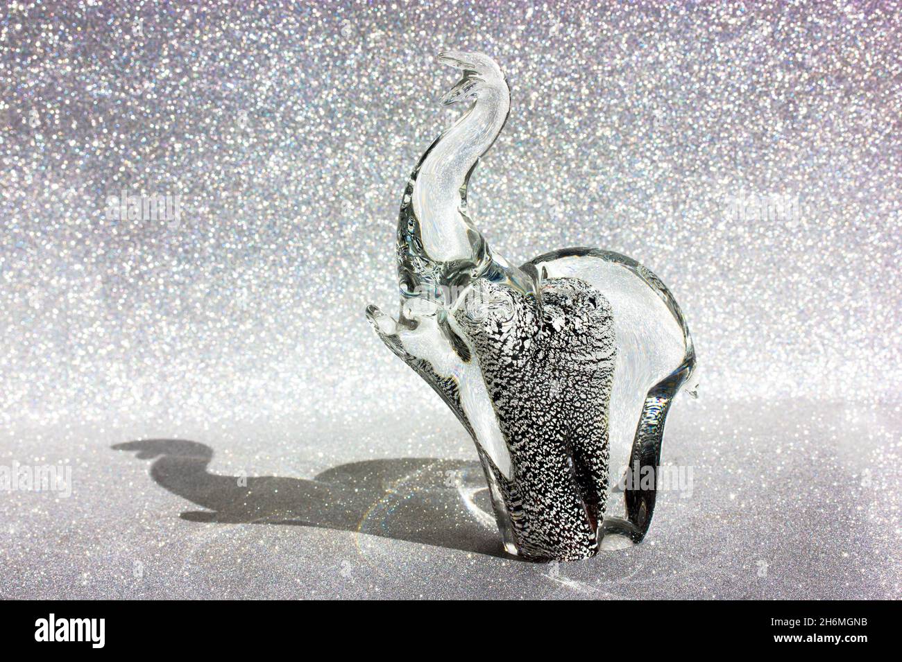 Figurine éléphant en verre de Murano sur fond argenté brillant.Talisman animal. Banque D'Images